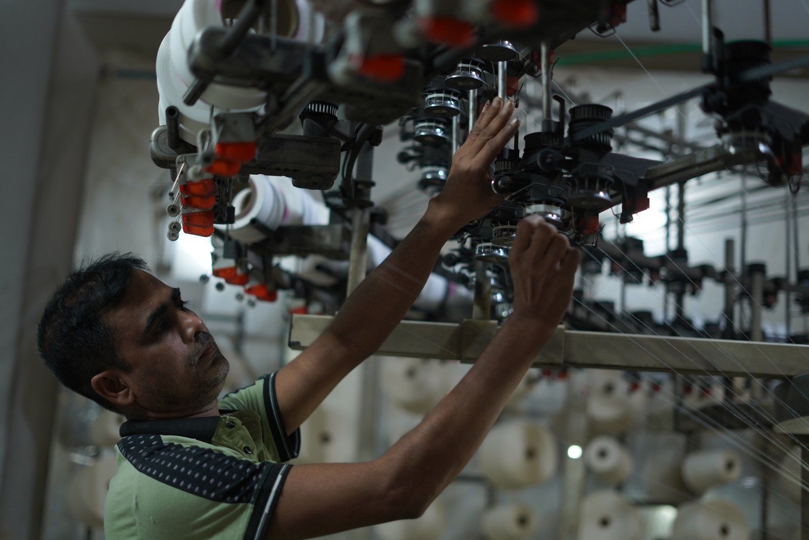 Worker operating a circular knitting machine